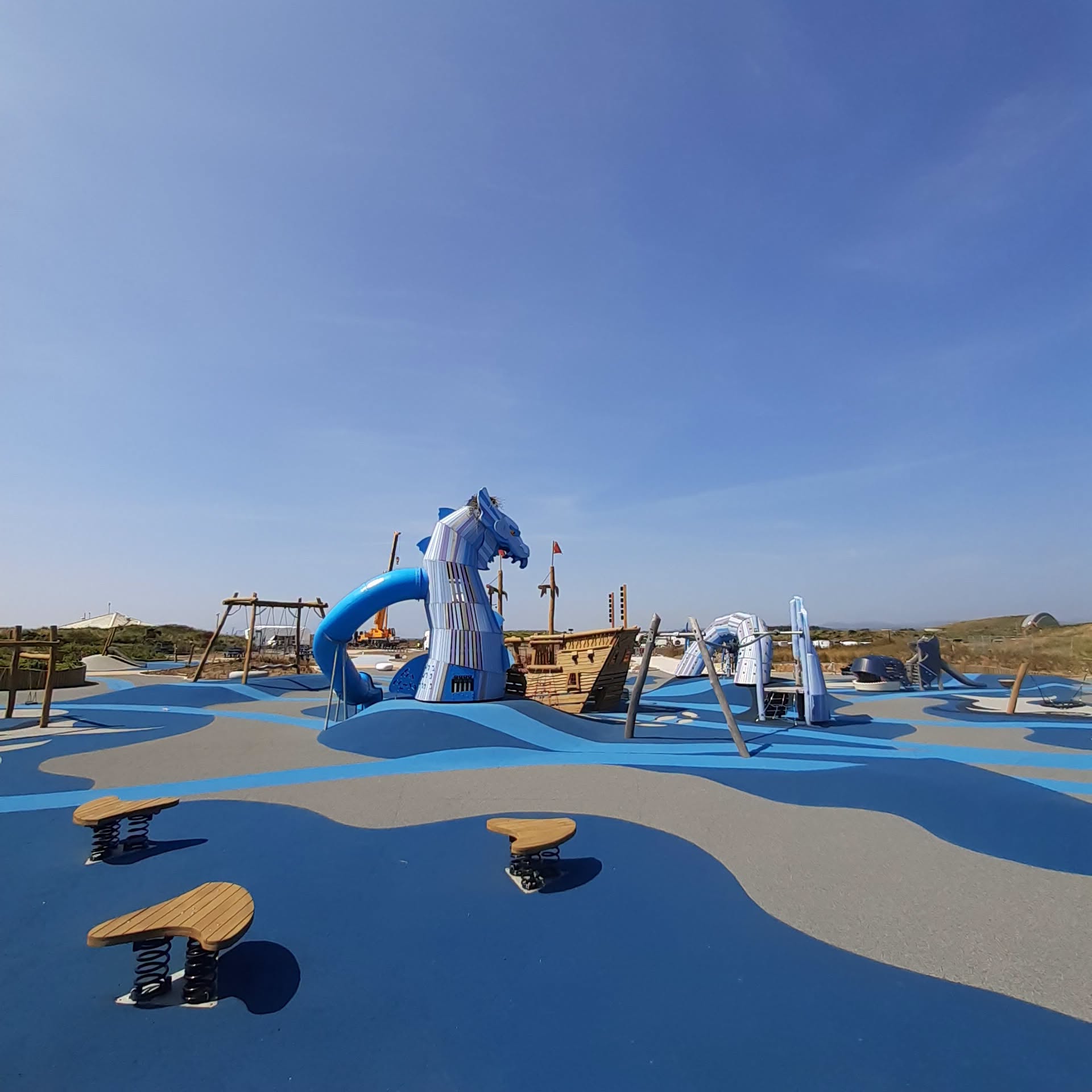 Blue sea-monster slide and wooden pirate ship at Irvine Beach Sea Monster Park